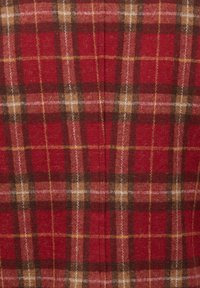 Tessuto a quadri rossi con motivi incrociati di strisce marroni e gialle. Morbida texture con un aspetto caldo e simile alla lana.