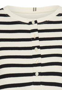 Zwart-wit gestreept shirt met een ronde halslijn, voorzien van vijf knopen aan de voorkant, gemaakt van een zachte brei stof.