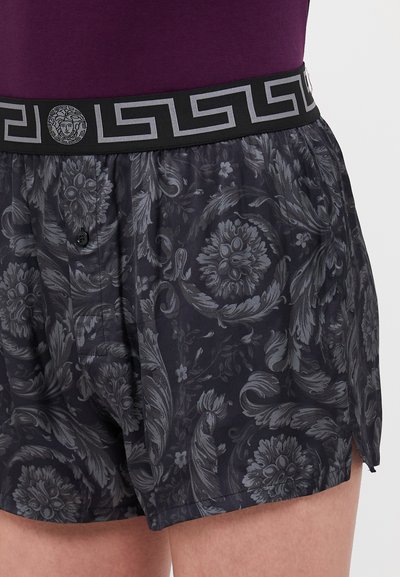 Boxers noirs avec un motif floral gris, dotés d'une ceinture noire ornée d'un design grec en gris et d'un emblème de Méduse.