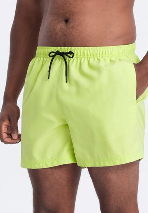 Lyse limegrønne badeshorts med elastisk talje og sort snor. Har to sidelommer og en glat, let tekstur.