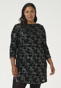Robe en sequins noirs avec un motif floral, manches trois-quarts, décolleté rond et silhouette ajustée. Le matériau a une texture brillante.