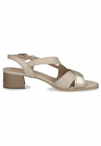 Sandal in pelle beige con design a strappo incrociato, accento metallico, punta aperta e tacco basso texturizzato. Fibbia alla caviglia regolabile per una vestibilità perfetta.