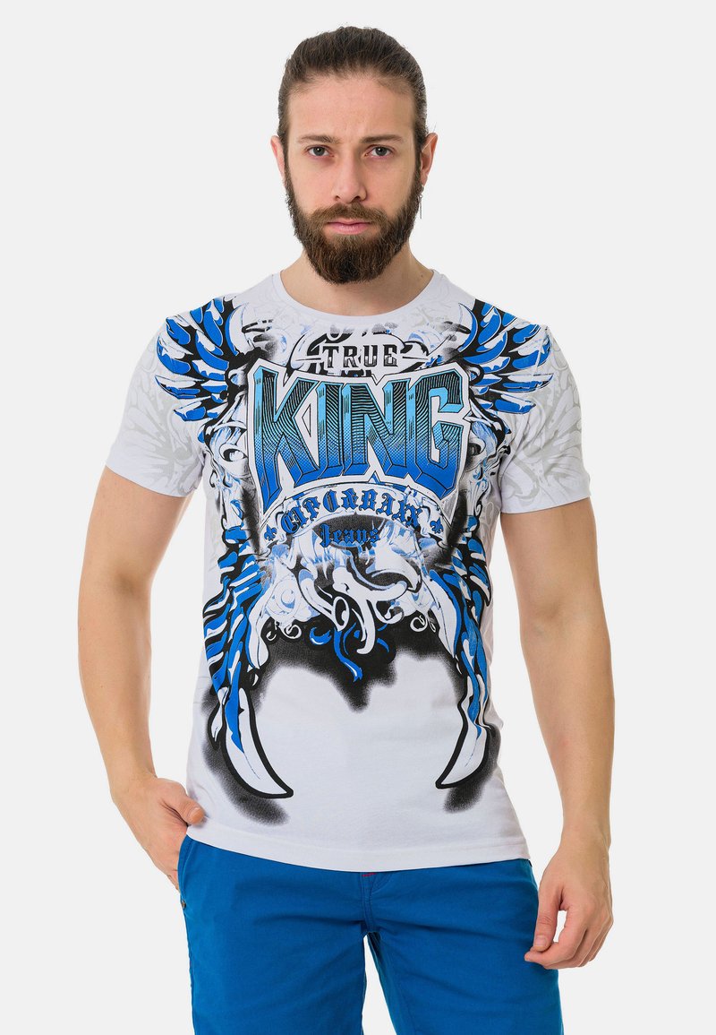 Weißes T-Shirt mit auffälligem blauem und schwarzem Grafikdesign sowie dem Text "ECHTER KÖNIG." Kurze Ärmel und Rundhalsausschnitt, mit einer figurbetonten Passform.