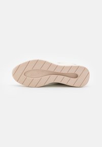 Sohle von ALDO Schuhen, cremefarben mit strukturierten Rillen, zeigt das Markenlogo. Flaches, gummiertes Material, das für Traktion und Komfort ausgelegt ist.
