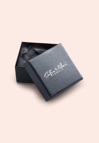 Svart texturerad smyckeskrin med ett lock som är något öppet, med den präglade logotypen "Sofia Mhlari Jewels" i vitt på toppen. Inuti finns svart papper.