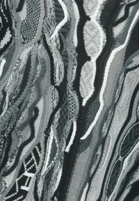 Abstrakcyjny wzór tekstylny przedstawiający splatające się czarne, białe i szare kształty o różnorodnych fakturach i wzorach, tworzące wizualną głębię.