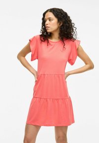Koralowa bawełniana sukienka z krótkimi falbaniastymi rękawami, okrągłym dekoltem, warstwowym krojem i kieszeniami. Gładka tekstura, luźny krój, długość powyżej kolan.