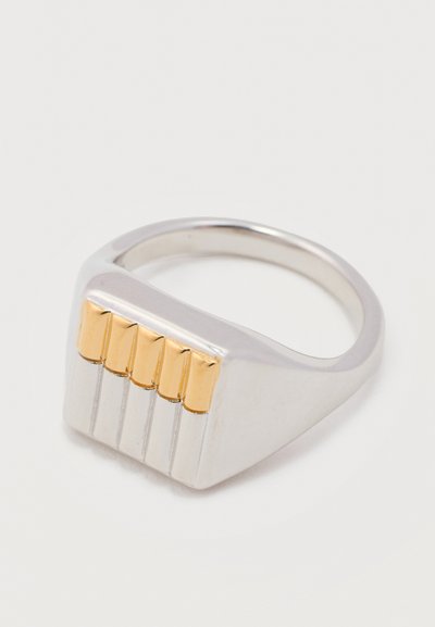 Ασημένιο δαχτυλίδι με επίπεδη ορθογώνια επιφάνεια που διαθέτει τέσσερις κάθετες χρυσές ράβδους τοποθετημένες ομοιόμορφα στην επιφάνεια.