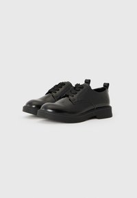 Chaussures en cuir noir avec une finition brillante, à bout rond, au design traditionnel à lacets et semelle en caoutchouc. Présentent une boucle pour un enfilage facile.