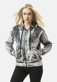 Hooded sweatshirt in black and white, featuring a textured pattern with handwritten details. Zip closure and front pockets. Soft fabric.