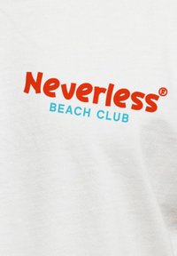 White cotton t-shirt featuring the text "Neverless" in bold red and "BEACH CLUB" in smaller turquoise, creating a contrasting design.