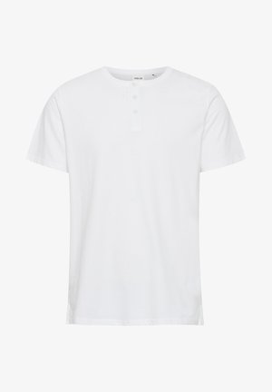 Valkoinen lyhythihainen t-paita pehmeästä kankaasta, jossa on pyöreä pääntie ja kolme nappia yksityiskohtana. Suora leikkaus ja sivu-avaukset.