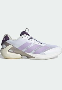 Basket de sport blanche avec des accents violets, dessus en maille et détails texturés. Présente un design de semelle géométrique unique et un système de laçage.