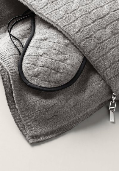 Gray knit blanket with a cable pattern, featuring a black trim and zipper closure. Smooth texture with a soft, warm appearance.