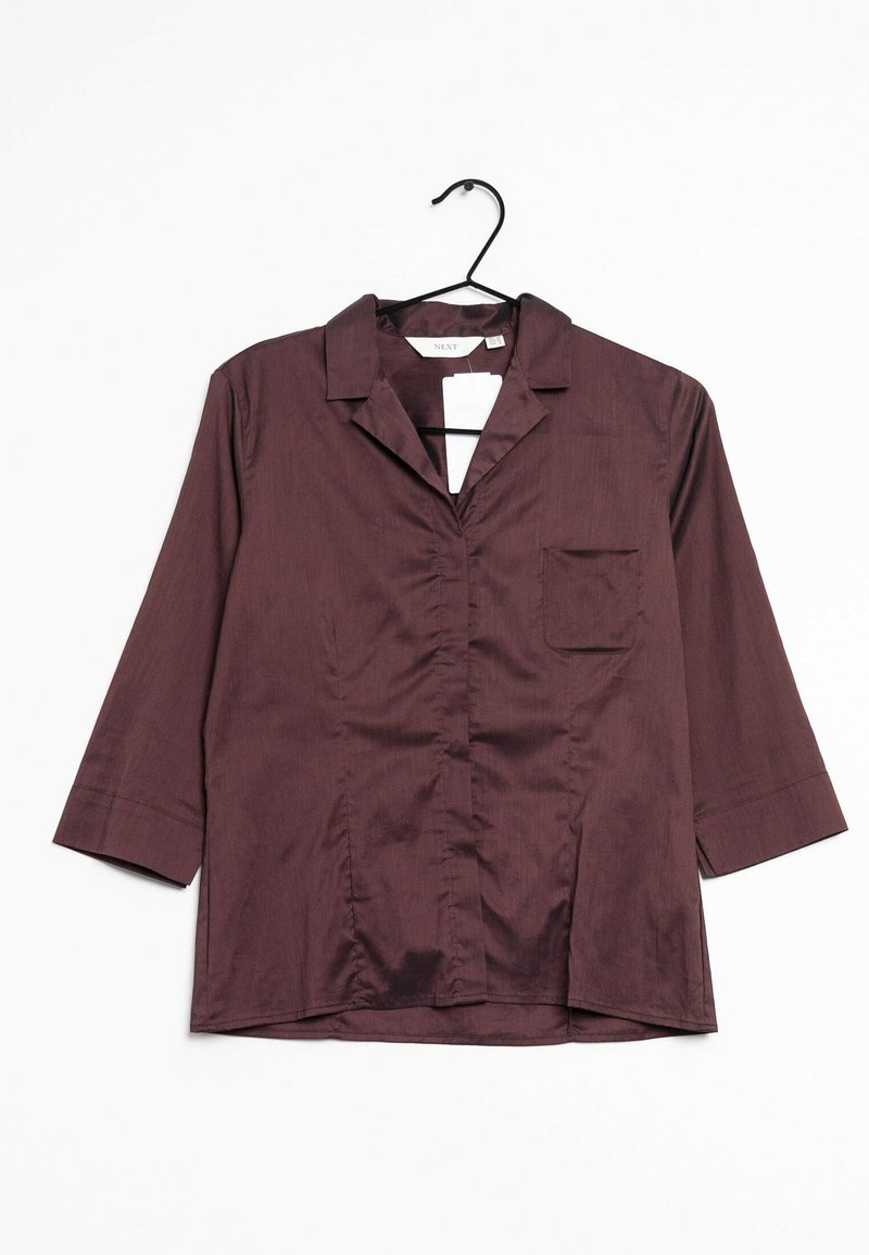 Camicia button-up bordeaux con colletto, maniche a tre quarti e una tasca sul petto; realizzata in un tessuto liscio con una leggera lucentezza.