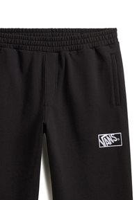 Zwart sweatbroek met een elastische tailleband, zakken aan de zijkant en een witte Vans logo patch aan de linkerkant. Glad stofoppervlak.
