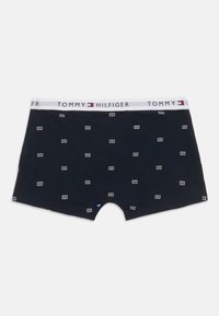Meeste tumesinised bokserid väikeste valgete logo mustritega ja valge vöökoht, millel on "Tommy Hilfiger" bränding.