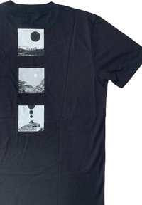 T-shirt nera in cotone con tre stampe grafiche quadrate sul retro, che raffigurano un sole e paesaggi montani in monocromia.