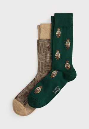 Zwei Paar Socken: Das eine dunkelgrün mit gestickten Figuren, das andere beige mit einem strukturierten Karomuster. Aus Baumwollmischung, Knöchellänge.