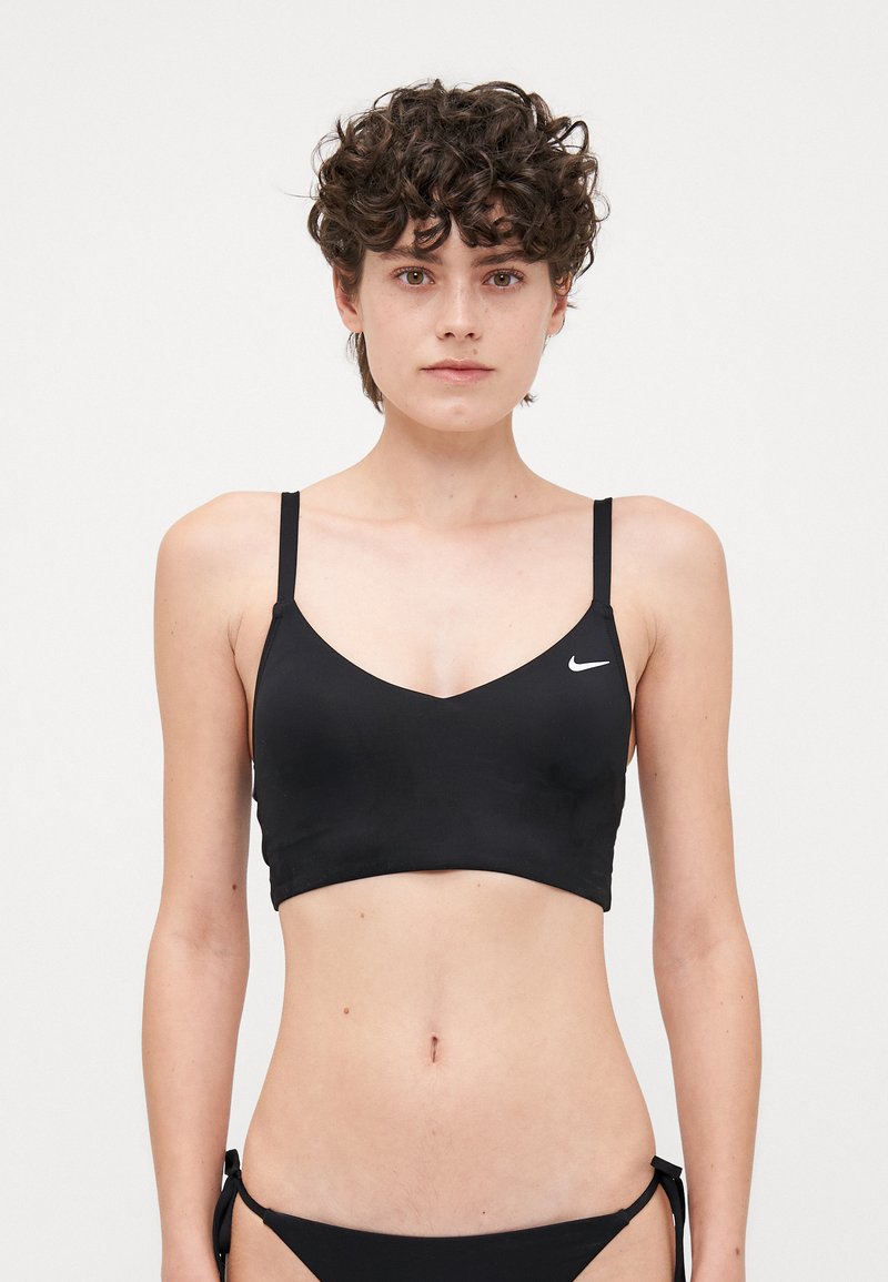 Black bikini top with thin straps, V neckline, and logo detail. Smooth, stretchy fabric with a fitted design. Simple and minimalistic style.