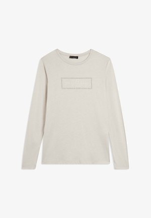 Maglietta a maniche lunghe di un tenue color crema con un logo rettangolare testurizzato sulla parte anteriore. Realizzata in cotone morbido con una vestibilità rilassata.