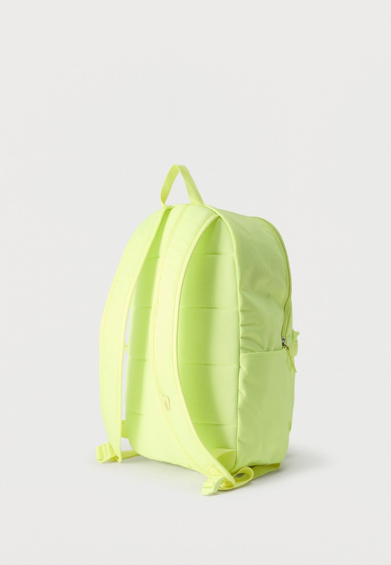 Mochila de neón amarillo con correas acolchadas para los hombros, asa superior y compartimento principal con cremallera sobre un fondo blanco liso.