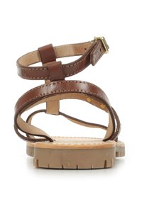 Sandalo in pelle marrone con multiple cinghie incrociate, cinturino alla caviglia regolabile e suola beige texture con scanalature per una presa sicura.