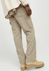 Beige corduroy cargobroeken met zijzakken en een rechte pasvorm, gecombineerd met tan schoenen met een dikke zool.