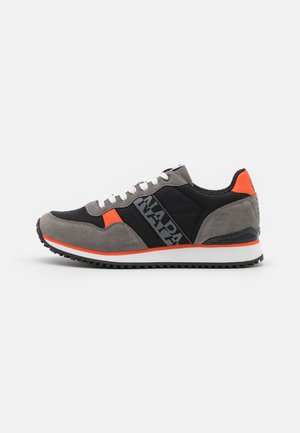 Sneaker grigio e nero con un accento arancione. Presenta materiali in camoscio e tessuto, una suola testurizzata e lacci per la chiusura.