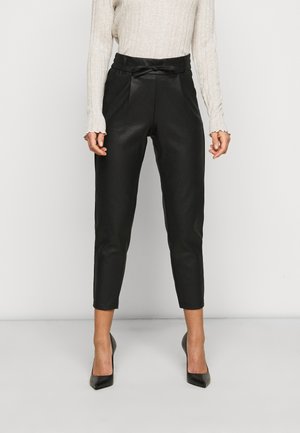 Pantalons cropped en simili cuir noir avec une taille ajustée et un détail nœud. Présente une texture lisse et une silhouette fuselée.