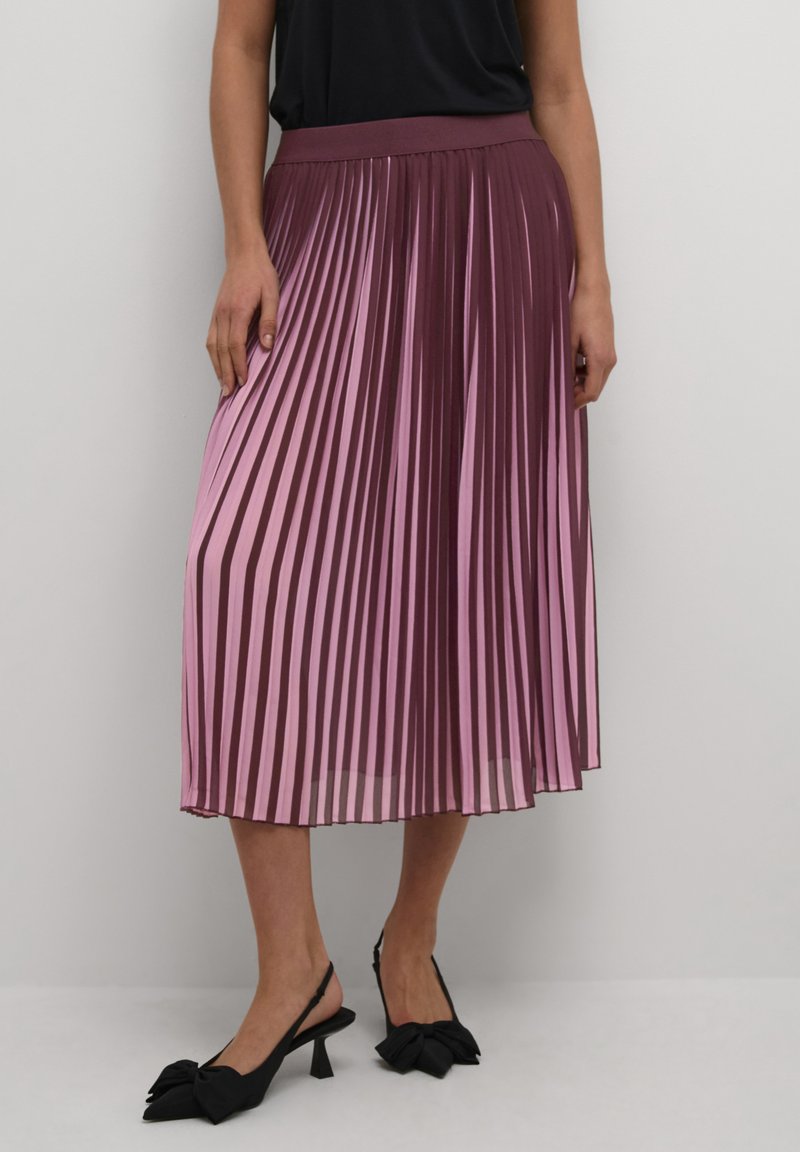 Faltender Midi-Rock in Burgunderrot und Pinkverlauf. Hergestellt aus leichtem Stoff mit einem elastischen Taillenbund. Kombiniert mit schwarzen Slingback-Schuhen mit Schleifen-Detail.