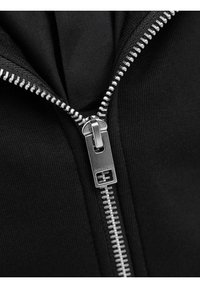 Crna zip-up dukserica s metalnim srebrnim zatvaračem, rebrastom teksturom tkanine i glatkom unutarnjom podstavom, prikazana iz otvorenog prednjeg pogleda.