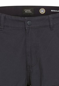 Marineblaue Shorts aus dehnbarem Material mit Reißverschluss, Knopfverschluss und einem Etikett mit der Aufschrift "camel active". Regular Fit Design.