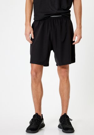 Sorte atletiske shorts lavet af letvægtsmateriale, med elastisk talje og afslappet pasform. Glat overflade, knælangt design.