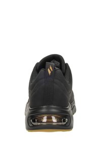 Schwarzer Sportschuh mit einer glatten, strukturierten Oberfläche, ausgestattet mit einer gepolsterten Sohle und einer transparenten Luftblase in der Ferse.