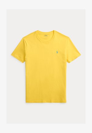 T-shirt en coton jaune avec un col rond et des manches courtes. Présente un petit logo bleu sur le côté gauche de la poitrine. Texture lisse.