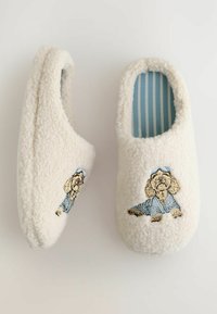 Mysiga cremafärgade tofflor i fleece-material, med blårandiga innersulor och broderad hunddesign i blått och beige.