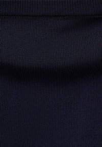 Gros plan d'un tissu côtelé bleu marine foncé tissé étroitement avec un pli horizontal visible au centre.