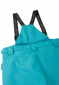 Turkusowe, wodoodporne ogrodniczki z regulowanymi czarnymi szelkami na ramiona, kieszenią na zamek z tyłu oraz przeszyciami na tkaninie.