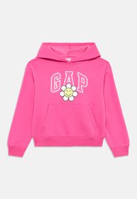 Sweatshirt rosa com um bolso frontal, apresentando um grande logo "GAP" e uma ilustração de uma flor com um rosto sorridente. Feito de um tecido macio.