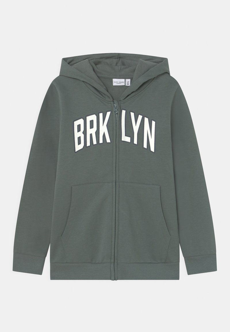 Sudadera verde con cremallera y la palabra "BRKLYN" impresa en blanco en el pecho. Cuenta con capucha y bolsillos frontales. Tejido suave, puños de canalé.