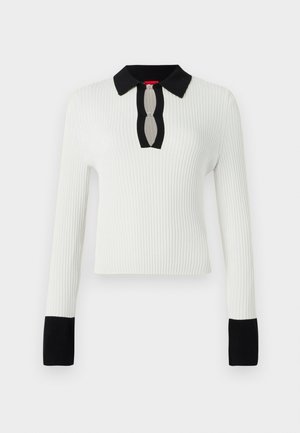 Top bianco a costine con colletto e polsini neri, caratterizzato da un dettaglio a forma di chiave sul collo. Maniche lunghe e design aderente.