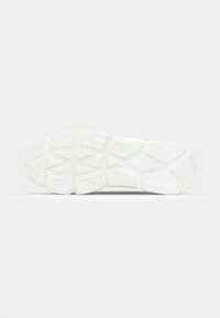 Semelle en caoutchouc blanche présentant des motifs texturés et des rainures, conçue pour l'adhérence avec une surface lisse et plate et des bords arrondis.