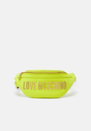 Banane jaune fluo avec un logo "LOVE MOSCHINO" doré brillant, fermeture éclair et bandoulière réglable. Matière synthétique lisse.