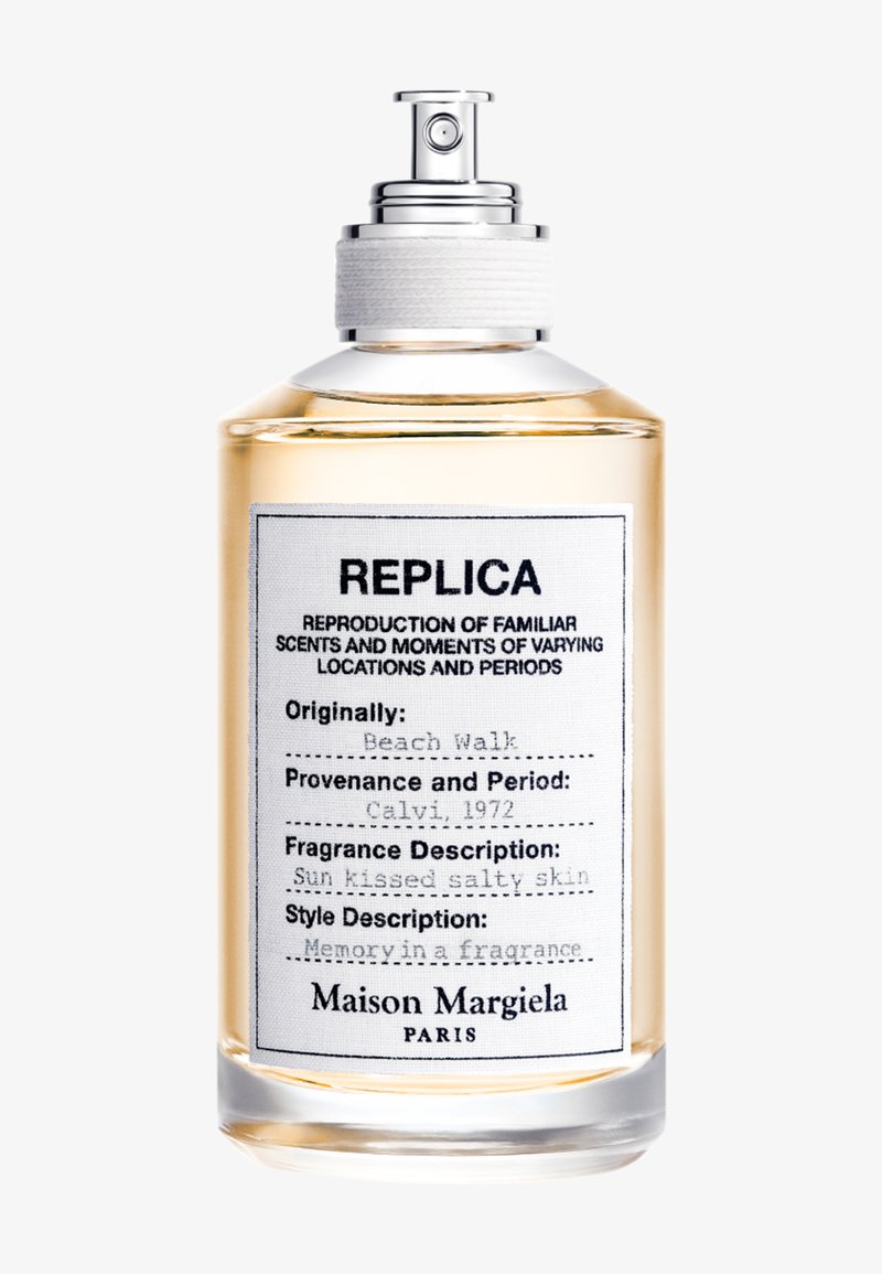 Przezroczysta szklana buteleczka perfum oznaczona Replica Maison Margiela z tekstem opisującym zapach Origin Beach Walk, pochodzenie Calvi 1972, zapach opalona słona skóra.
