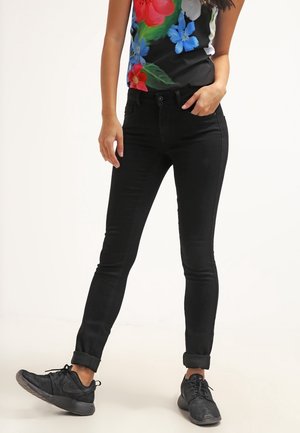 Jeans ajustados negros con una textura suave y un corte ceñido, que cuentan con un diseño clásico de cinco bolsillos y un dobladillo enrollado en los tobillos.