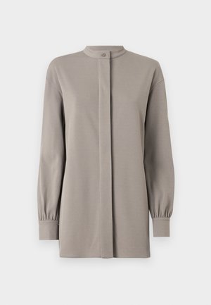 Világosszürke, hosszú ujjú felső, magas gallérral, elöl gombos záródással és redőzött ujjakkal, sima, kissé rugalmas anyagból készült.