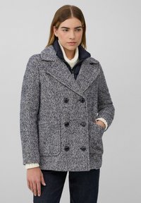 Doppelt ausgeführter Peacoat im Fischgrätmuster, mit marineblauen und grauen Tönen, großen schwarzen Knöpfen und einem strukturierten Strickkragen.