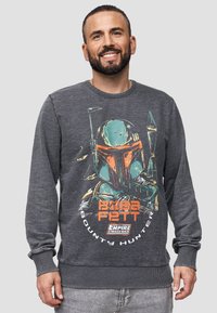 Sudadera gris de cuello redondo hecha de tela suave, con un gráfico colorido de Boba Fett y el texto "Cazador de recompensas Boba Fett".