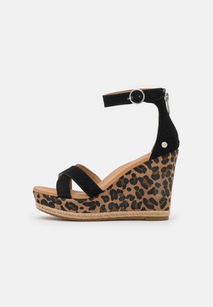 Sandales compensées en daim noir avec une plateforme à imprimé léopard, dotées d'une bride à boucle et de détails tissés à la base.